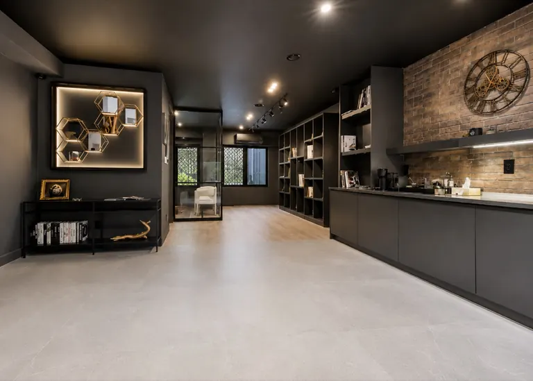 The lounge at the design centre, with a coffee bar, a brick wall and shelves of sample books
