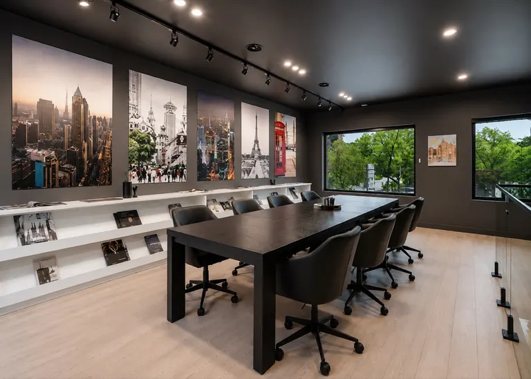The meeting room at the design centre, a long table under a wall of framed prints beside a window