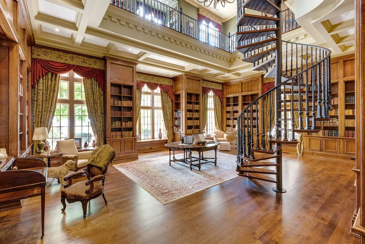 A double-height wood-panelled library with a spiral staircase, arched windows and shelves to the ceiling