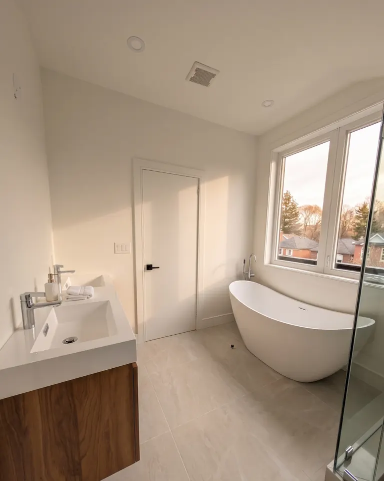 Finished bathroom with a freestanding tub beneath a window