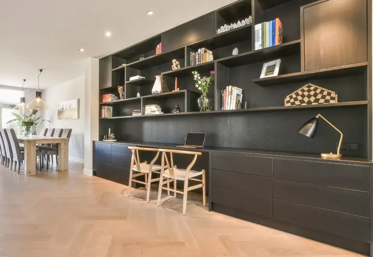 Finished home office with floor-to-ceiling dark built-in joinery and herringbone flooring