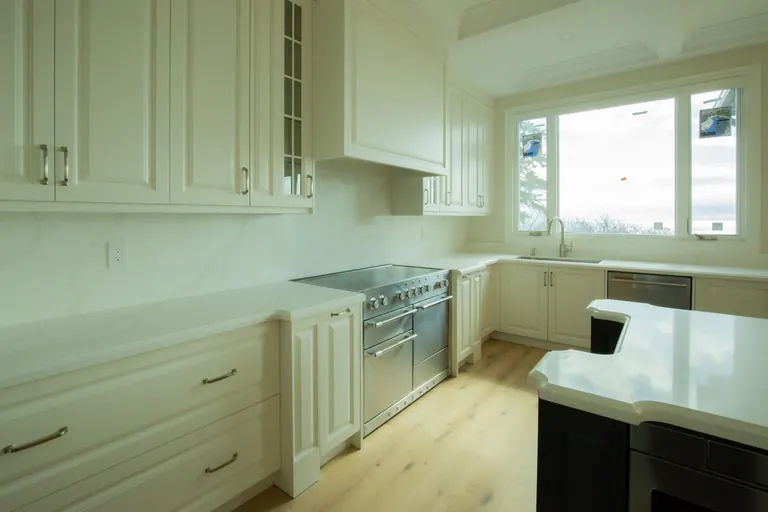 Finished kitchen under a coffered ceiling with a marble island