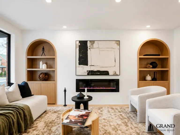 Finished living room with arched built-in niches either side of a linear fireplace