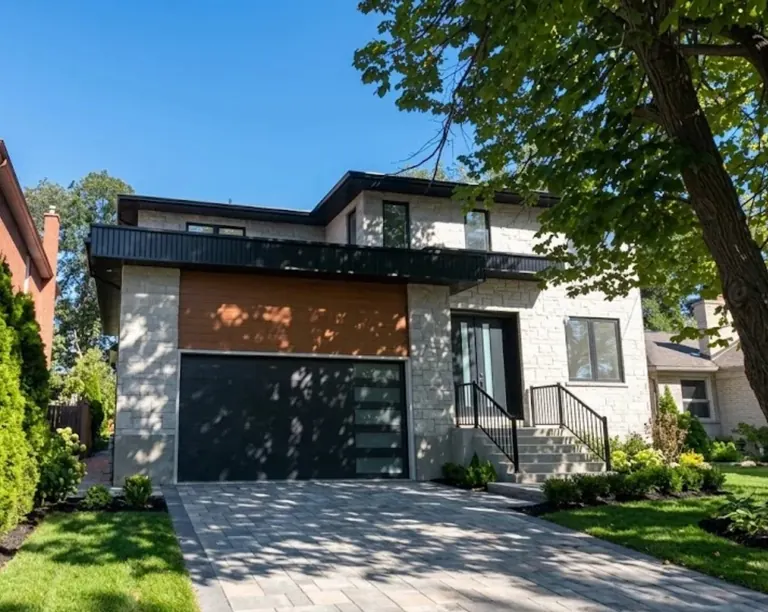A finished two-storey custom home on Treelawn Parkway: pale limestone across the front, a cedar-clad panel over the garage, a black metal fascia band under the upper storey, and a new paver driveway
